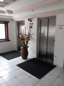 een lobby met een lift en een vaas met een plant bij Apartamento inteiro in Praia Grande
