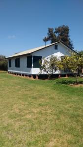 a white house with a field in front of it at cabañas sector peñuelas in Coquimbo