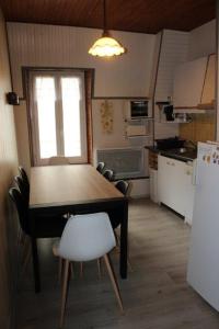 Una cocina con una mesa y sillas en una habitación. en "Le 5" RÉSIDENCE BROUSSE, en Le Mont-Dore