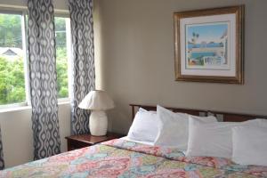 a bedroom with a bed and a lamp and windows at Turtle Beach Towers Apt 22 C - Ocho Rios in Ocho Rios +45 photos