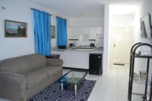 a living room with a couch and a kitchen at Sky Castles Apt H6 in Ocho Rios