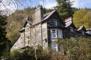 an old stone house on the side of a mountain at Woodlands Centre in Betws-y-coed