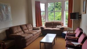 a living room with a couch and chairs and a table at Woodlands Centre in Betws-y-coed