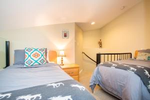 a bedroom with two beds and a lamp on a table at R & R Retreat Luxury Condo in Whistler