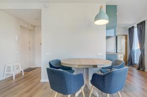 a dining room with a wooden table and blue chairs at City View Apartment 57 in Vilnius