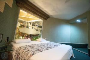 a bedroom with a large bed with a window at New York Hotel/Motel in Orizaba