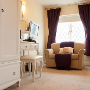 a living room with a chair and a table at Norfolk Arms Hotel, Ringinglow in Sheffield