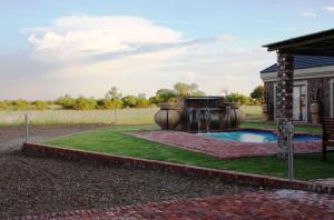 a backyard with a swimming pool and a house at Almar Exclusive Game Ranch in Bloemhof