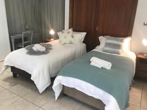 two beds in a hotel room with towels on them at Taj on Byrnes - Private Luxury Apartment Mareeba in Mareeba