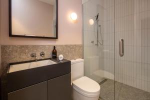 a bathroom with a shower and a toilet and a sink at The Chamberson in Dunedin +37 photos
