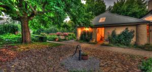 una casa con un albero e una passerella di Old WesleyDale Heritage Accommodation a Mole Creek