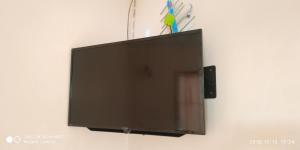TV de pantalla plana colgada en la pared en Montra Guesthouse, en Ranong