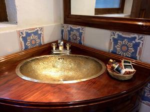 baño con lavabo de oro en una encimera de madera en La Montaña, en San Cristóbal de Las Casas