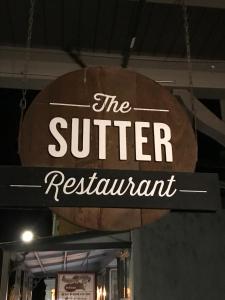 a sign for the surfer restaurant hanging from a ceiling at Hotel Sutter in Sutter Creek