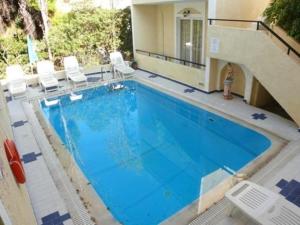 a large swimming pool with chairs and a house at Senia Studios in Agia Marina Aegina