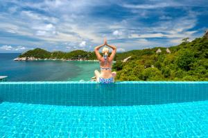 una mujer en bikini parada en la parte superior de una piscina en Villas Sabai Jai en Ko Tao