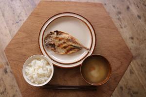 a table with a plate of food and a bowl of rice at Guest House MARUYA in Atami +72 photos
