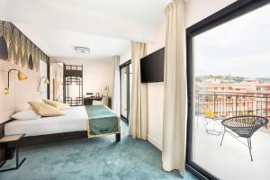 um quarto de hotel com uma cama e uma varanda em Best Western Hôtel Journel Saint-Laurent-du-Var em Saint-Laurent-du-Var
