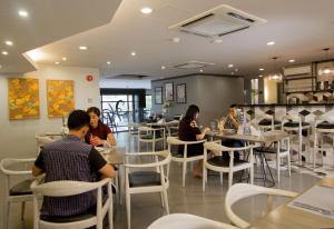 eine Gruppe von Personen, die in einem Restaurant an Tischen sitzen in der Unterkunft Cebu Hotel Plus in Cebu City