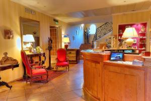 eine Lobby mit einer Bar mit roten Stühlen und einer Treppe in der Unterkunft Best Western L'Orangerie in Nîmes