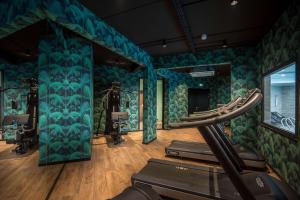 a gym with a room with cardio equipment and a treadmill at Best Western Plus Hostellerie Du Vallon in Trouville-sur-Mer