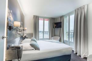 a hotel room with a bed and a large window at Best Western ARThotel in Le Havre