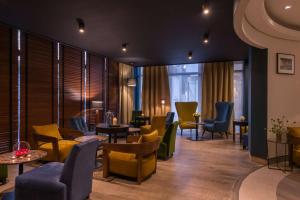 a waiting room with chairs and tables and windows at Best Western Hotel le Galice Aix-en-Provence in Aix-en-Provence