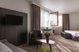 エクス・アン・プロヴァンスにあるBest Western Hotel le Galice Aix-en-Provenceのベッドとリビングルームがあるホテルの部屋