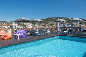 - une piscine sur le toit avec des chaises et des parasols dans l'établissement Best Western Plus Cannes Riviera, à Cannes