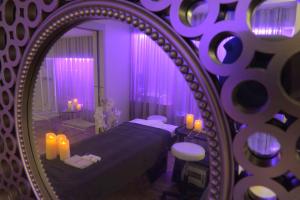 a purple bedroom with a bed and a mirror at Best Western Les Bains Hotel et SPA in Perros-Guirec