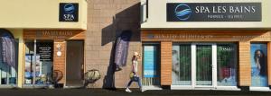 a woman walking in front of a store at Best Western Les Bains Hotel et SPA in Perros-Guirec