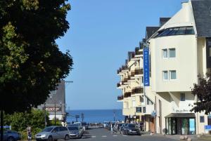 a street with cars parked on the side of a building at Best Western Les Bains Hotel et SPA in Perros-Guirec