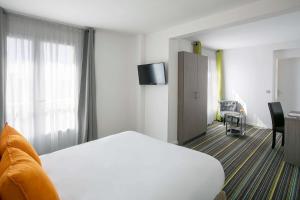 Best Western Hôtel des Thermes - Balaruc les Bains Sète tesisinde bir odada yatak veya yataklar