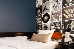 Best Western Hotel Nürnberg am Hauptbahnhof في نورنبرغ: غرفة نوم مع سرير مع ملصقات على الحائط
