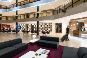 a lobby with couches and people walking in a building at Best Western Plus Parkhotel Velbert in Velbert