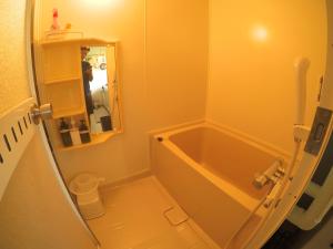 a bathroom with a bath tub in a room at NORD house in Iwamizawa