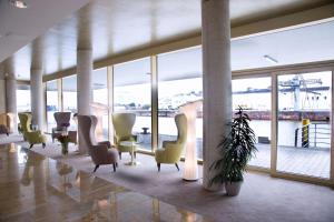 a lobby with chairs and tables and a large window at Best Western Plus Hotel Bremerhaven in Bremerhaven