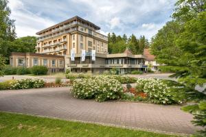 ein großes Gebäude mit weißen Blumen davor in der Unterkunft Sure Hotel by Best Western Bad Dürrheim in Bad Dürrheim