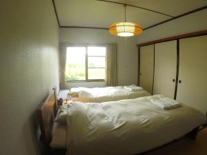a room with two beds and a window at NORD house in Iwamizawa