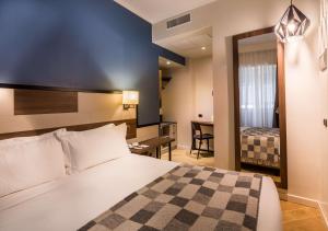 a hotel room with a bed and a desk and a bedroom at Best Western Hotel Metropoli in Genoa