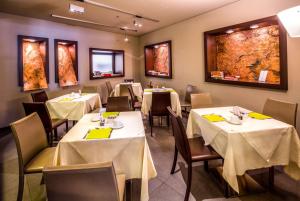 Best Western Hotel Metropoli في جينوا: غرفة طعام مع طاولات وكراسي بمناديل صفراء