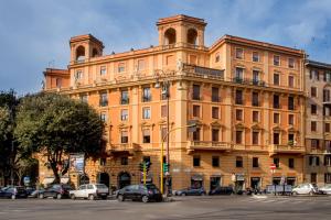 ein großes orangenes Gebäude mit davor geparkt in der Unterkunft Best Western Hotel Astrid in Rom