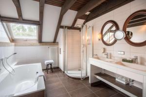 a bathroom with a tub, sink, mirror and bathtub at Best Western Hotel Polisina in Ochsenfurt