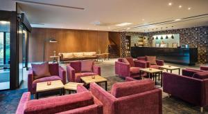 a waiting room with red chairs and a piano at Best Western Hotel Kaiserslautern in Kaiserslautern