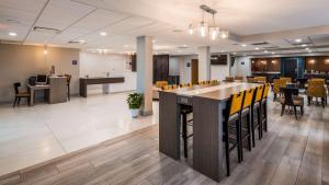 an office lobby with a bar with yellow chairs at Best Western Plus Bloomington East in Bloomington