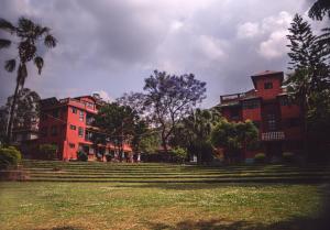 a group of buildings in a park with a grass field at Bhaktapur Guest House in Bhaktapur