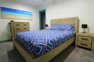 a bedroom with a bed with a blue comforter at Bombora, 3/4 East Street in Crescent Head