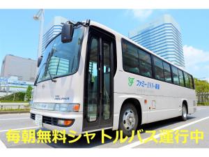 a white bus is parked on the street at Famy Inn Makuhari in Chiba