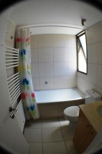 a small bathroom with a tub and a toilet at Apartamento Puerto Velero Tongoy in Puerto Velero