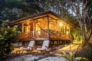 a cabin in the woods with chairs and lights at Boulder Bay Eco Resort - Nga Khin Nyo Gyee Island in Nga Khin Nyo Gyee Island
